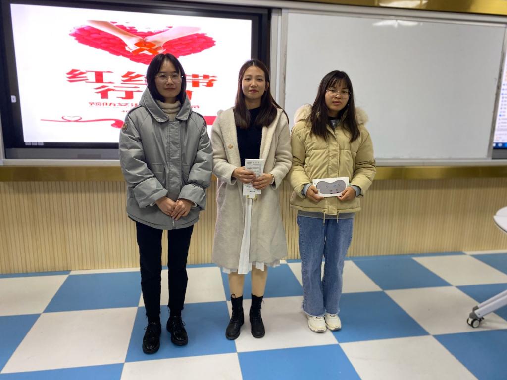 图为班主任李胜丹(左一)给同学们颁奖并合影留念