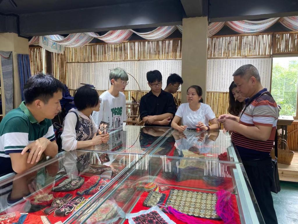 图为传承人李素芳在详细介绍瑶族服饰图案