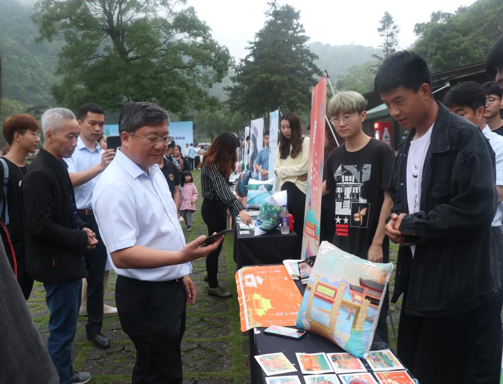 图为贺州市人民政府副市长杨育智(左二)参观yl34511线路中心数字媒体艺术专业作品展览