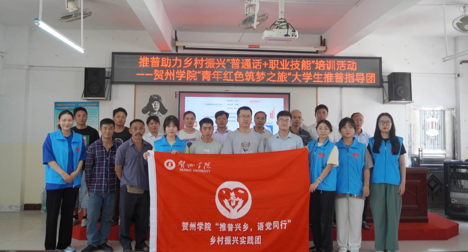 图为志愿者在给狮东村村委工作人员合影